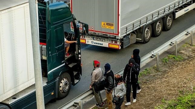 Un grupo de inmigrantes conversa con transportistas en Calais