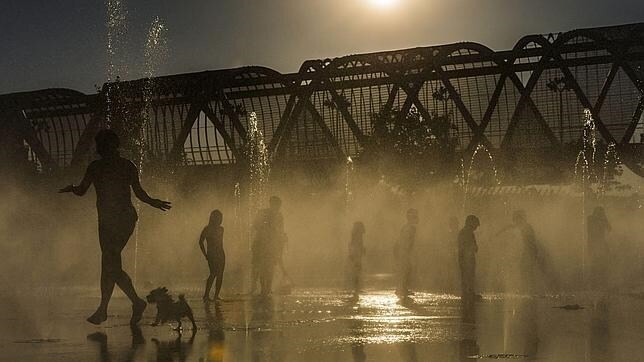 Varoas personas se refrescan en las fuentes de Madrid Río ante la ola de calor