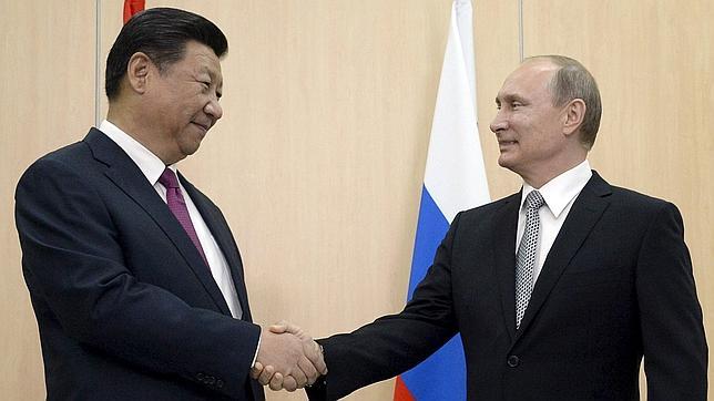 Vladimir Putin y Xi Jinping se estrechan la mano durante un encuentro