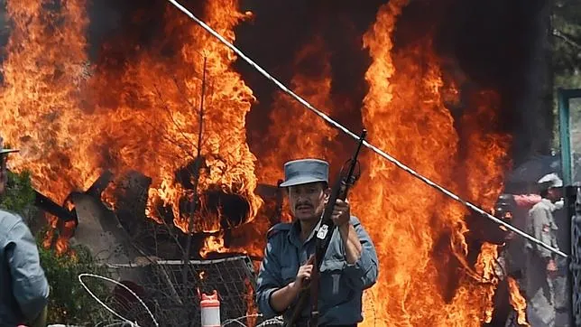 Un oficial de la policía afgana, ante el incendio provocado por una explosión en las inmediaciones del aeropuerto de Kabul