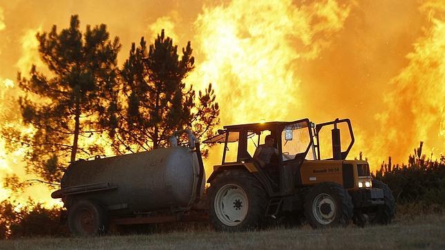 Un vecino combate las llamas en uno de los incendios forestales declarados en Galicia