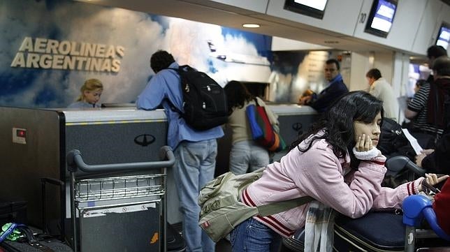 Unos pasajeros facturan en el mostrador de Aerolíneas Argentinas en el aeropuerto de Buenos Aires
