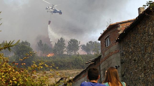 Un helicóptero trabaja para sofocar uno de los fuegos de estos días en Galicia