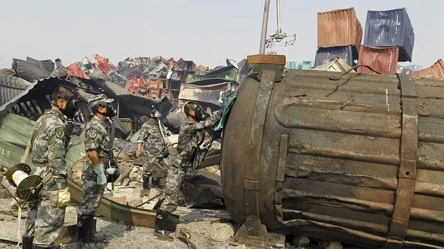 Unos soldados, con máscaras de seguridad, inspeccionan un contenedor en Tianjin