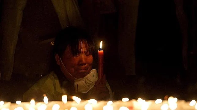 Una mujer sostiene una vela durante uno de los actos de homenaje por las víctimas de Tianjin