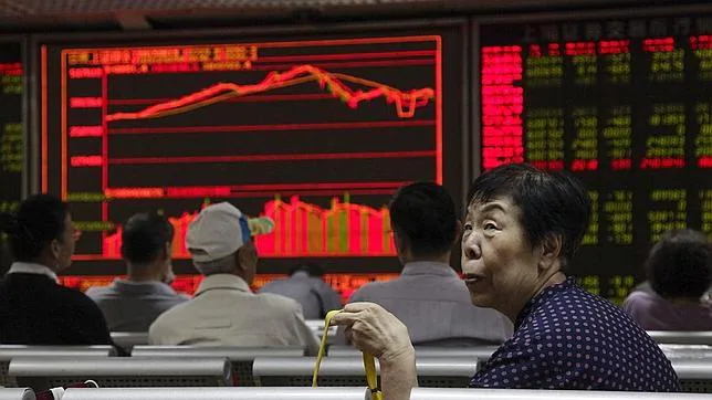Un grupo de inversores observan la caída del índice de Shanghái