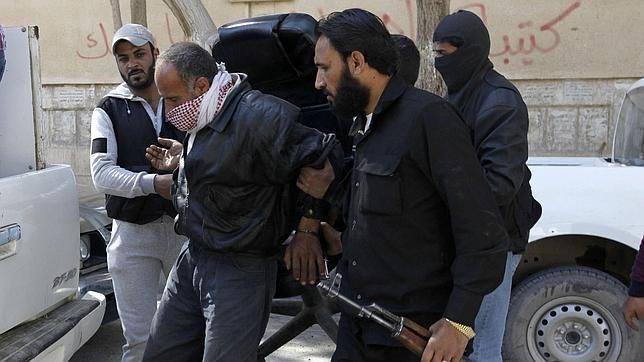 Miembos del grupo yihadista trasladan a un prisionero a Raqqa