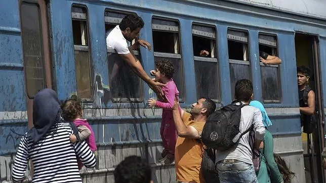 Un grupo de inmigrantes intenta subir a bordo de un tren en la estación de Gevgelija, en Macedonia