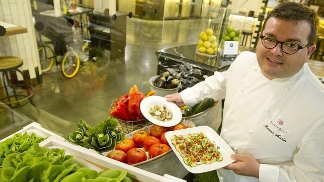 El chef Marcos Morán sujeta dos de las ensaladas de la carta de La Huerta de Merchina