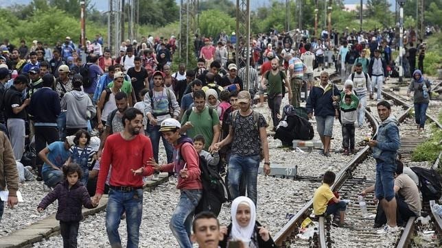 Varios inmigrantes caminan por las vías del tren, en la ciudad de Gevgelija, Macedonia