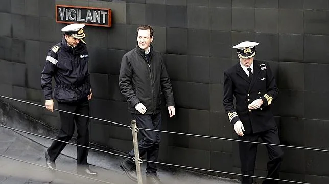El ministro de Finanzas británico, George Osborne, camina sobre la cubierta de un submarino en su visita a la base naval de Falsane