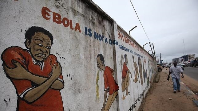 Un hombre pasa frente a un mural en Monrovia (Liberia), este jueves
