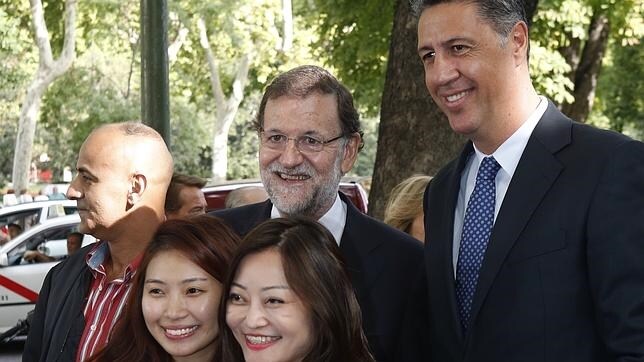 Mariano Rajoy y Xavier García Albiol este miércoles en Madrid junto a dos ciudadanas de Singapur