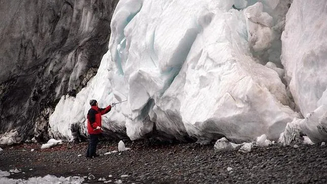 Una investigadora inspecciona un bloque de hielo en la Isla Decepción (Antártida).