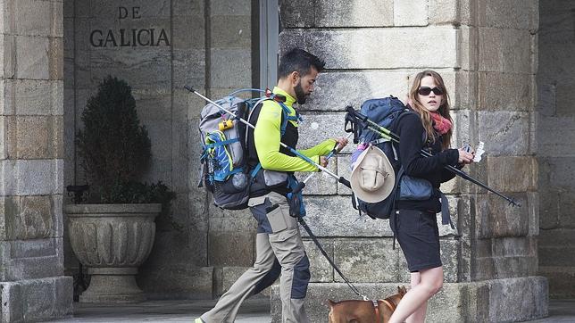 Dos peregrinos pasan junto a la sede de la Xunta en la plaza del Obradoiro, en Santiago