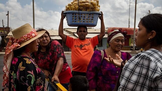 Un grupo de personas de la etnia Wayúu aguarda para poder cruzar la aduana entre Venezuela y Colombia