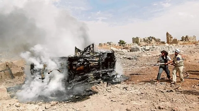 Unos sirios apagan el incendio provocado por un bombardeo ruso en Hass, en las inmediaciones de Idlib