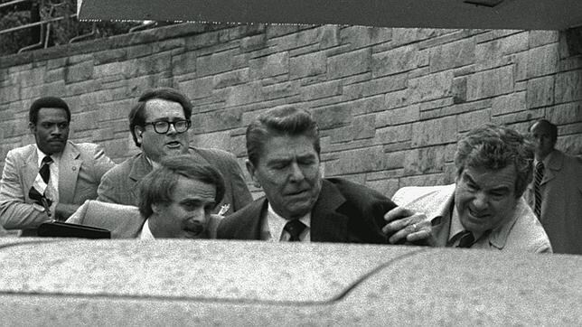 Momento en el que el Servicio Secreto empuja a Reagan a entrar en el coche