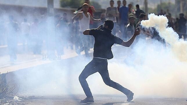 Un palestino lanza gaz lacrimógeno contra soldados israelíes durante un enfrentamiento en el norte de la Franja de Gaza