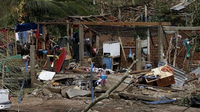 Una niña mira cómo ha dejado su casa destruida el huracán Patricia