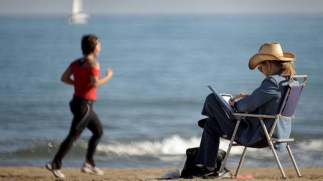 Una mujer se protege la cabeza con un sombrero