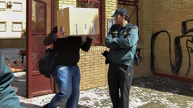 Un agente de la UCO de la Guardia Civil sacando una caja de la casa del exsindicalista de UGT Juan Lanzas