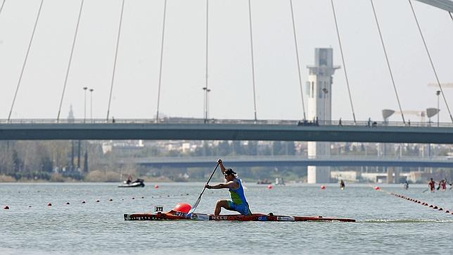 Un remero en el Guadalquivir, con el puente de la Barqueta de fondo