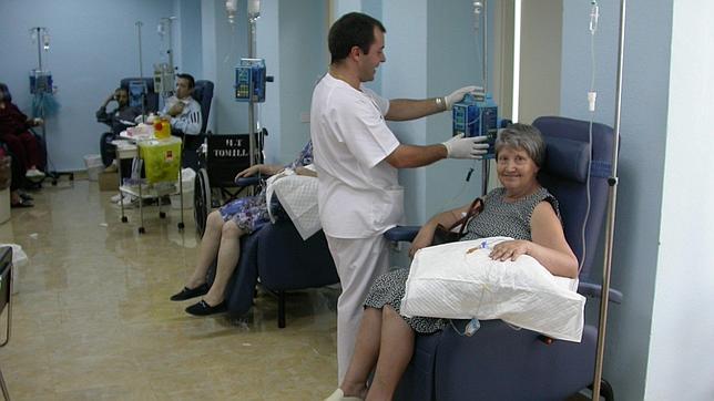 Un enfermero junto a una paciente en una sala hospitalaria