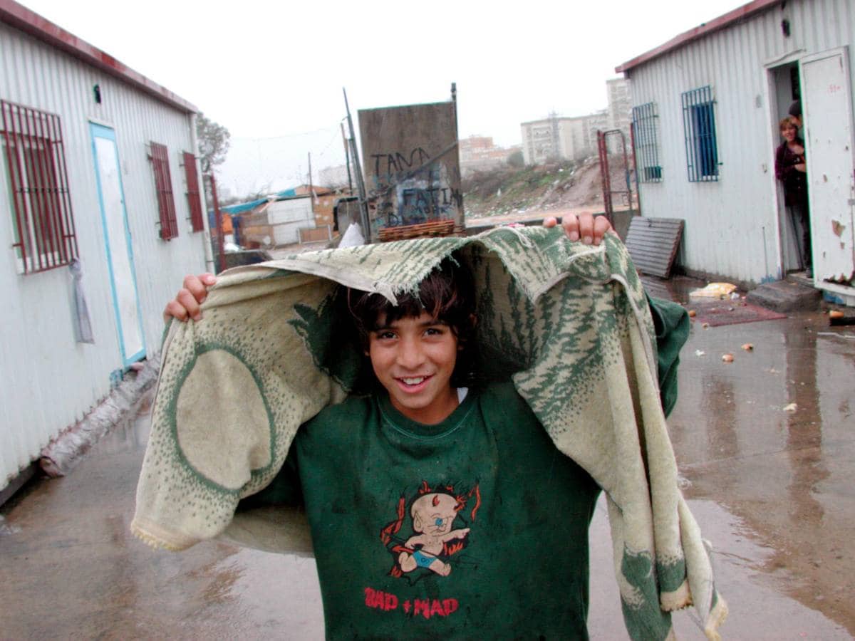 La historia del Vacie, en imágenes. Un niño se cubre de la lluvia con una prenda roñosa