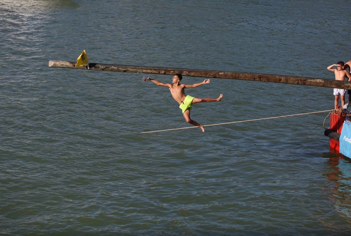 La tradicional cucaña de la Velá de Triana, en imágenes