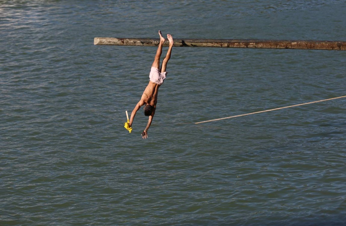 La tradicional cucaña de la Velá de Triana, en imágenes