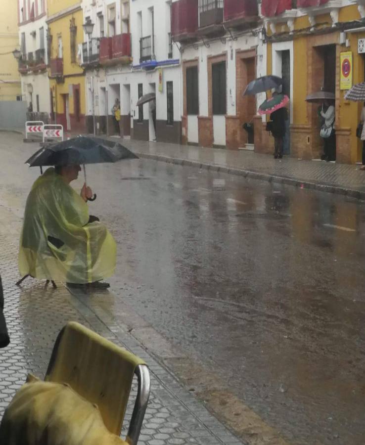 Un hombre espera bajo su paraguas en la calle Pureza