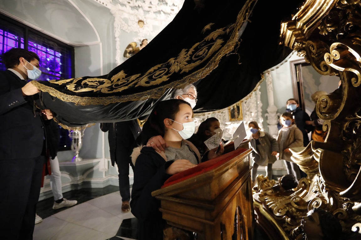 Los niños pasan bajo el manto de la Virgen de los Dolores de Córdoba, en imágenes