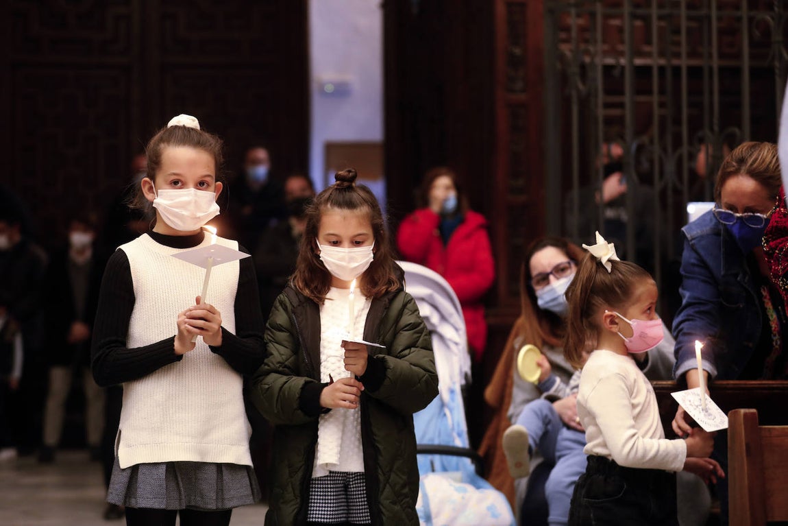 Los niños pasan bajo el manto de la Virgen de los Dolores de Córdoba, en imágenes