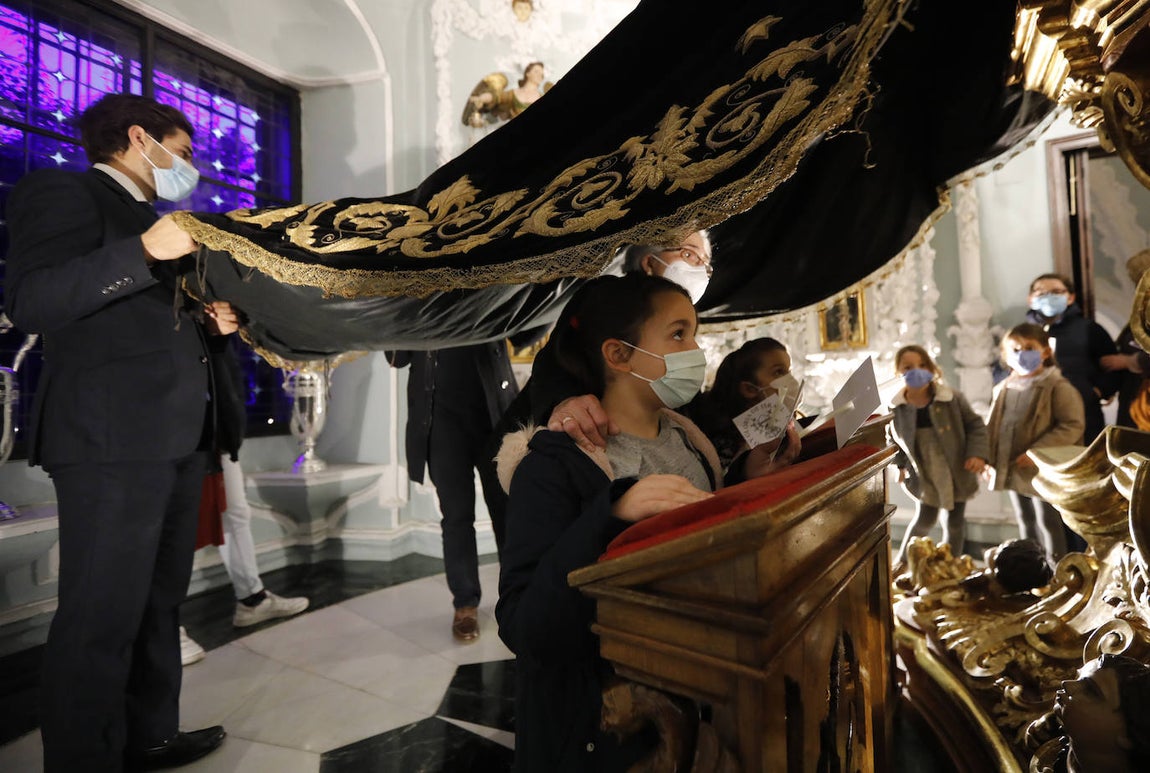Los niños pasan bajo el manto de la Virgen de los Dolores de Córdoba, en imágenes