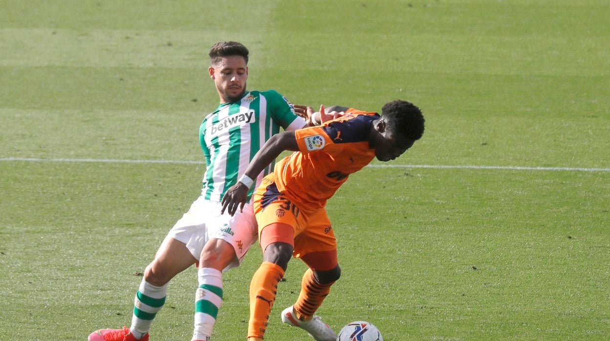 Álex Moreno pugna con un rival durante el Betis - Valencia