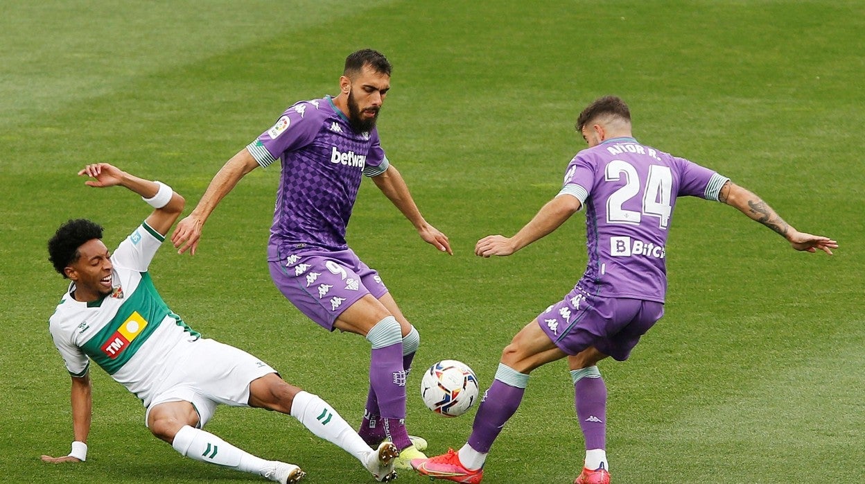 Borja Iglesias y Aitor Ruibal disputan una pelota con Mojica en el Elche - Betis de la pasada temporada