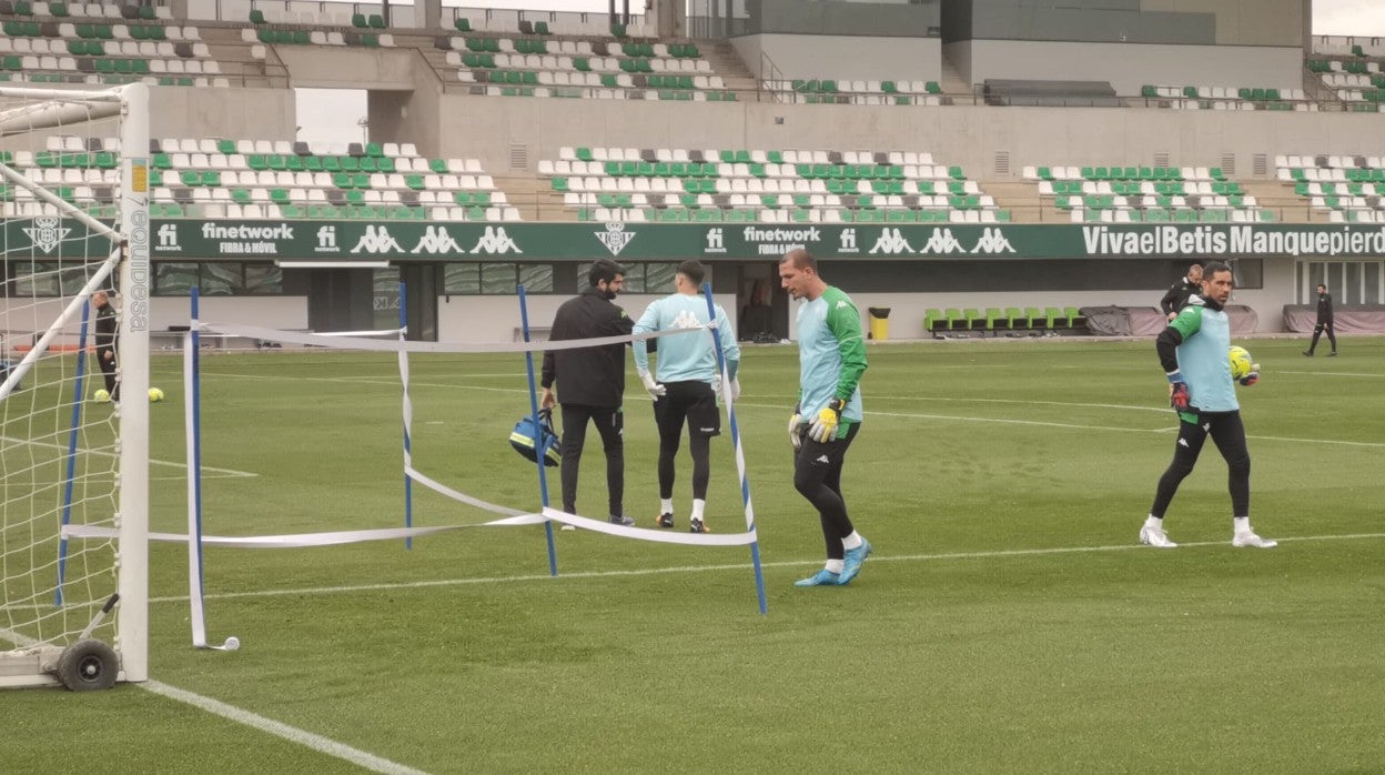 Rui Silva se marcha asistido por uno de los fisioterapeutas del Betis tras lesionarse en el ejercicio con Joel Robles y Claudio Bravo