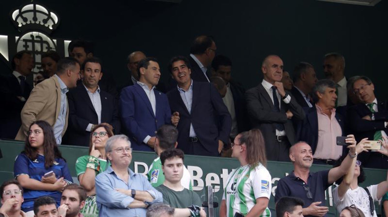 Juanma Moreno y Ángel Haro dialogan en el palco del Betis