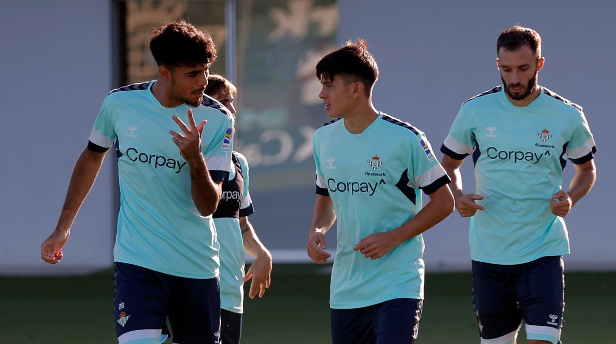 Chadi Riad dialoga con Dani Pérez ante Pezzella durante un entrenamiento del Betis