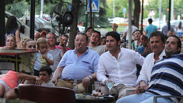 Un grupo de personas disfruta de un partido en la terraza de un bar
