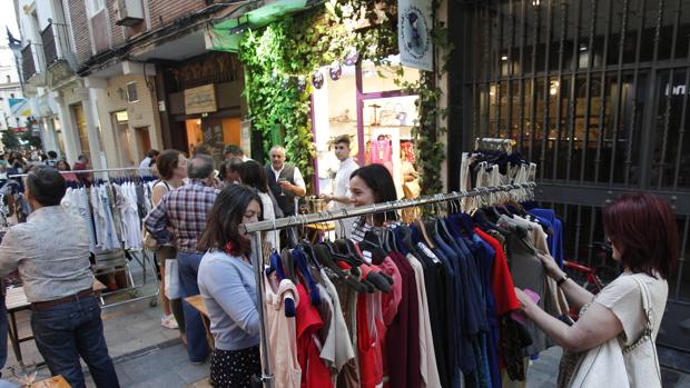 Clientas observan una percha con ropa en plena calle