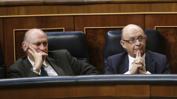El ministro Cristóbal Montoro, en su escaño, junto a Jorge Fernández