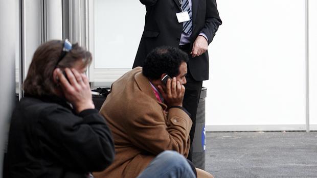 Dos personas hablan por su teléfono móvil