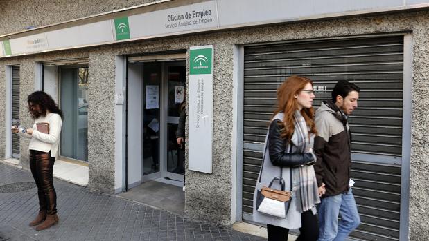 Una pareja pasa frente a una oficina de empleo de la capital