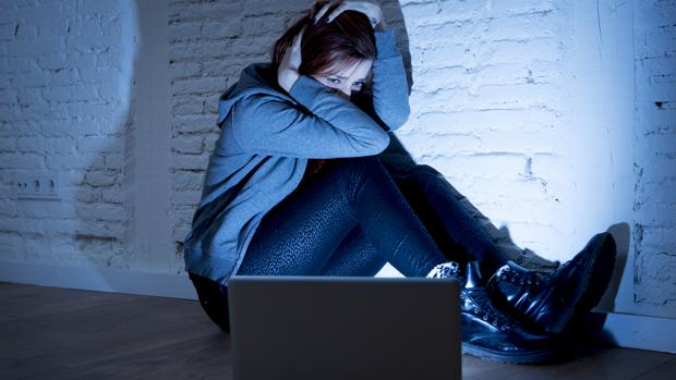 Una mujer asustada frente a un televisor