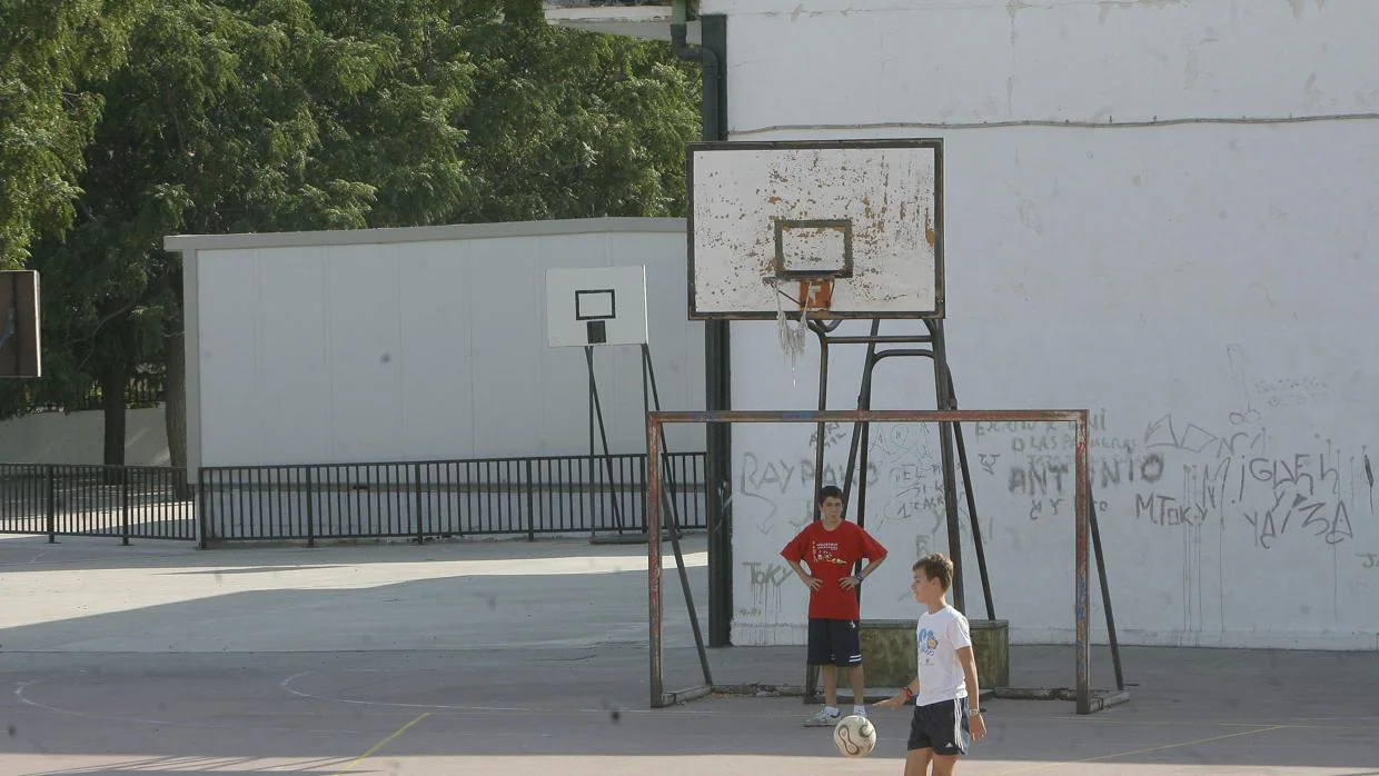 Dos niños juegan en el patio del colegio Al-Andalus