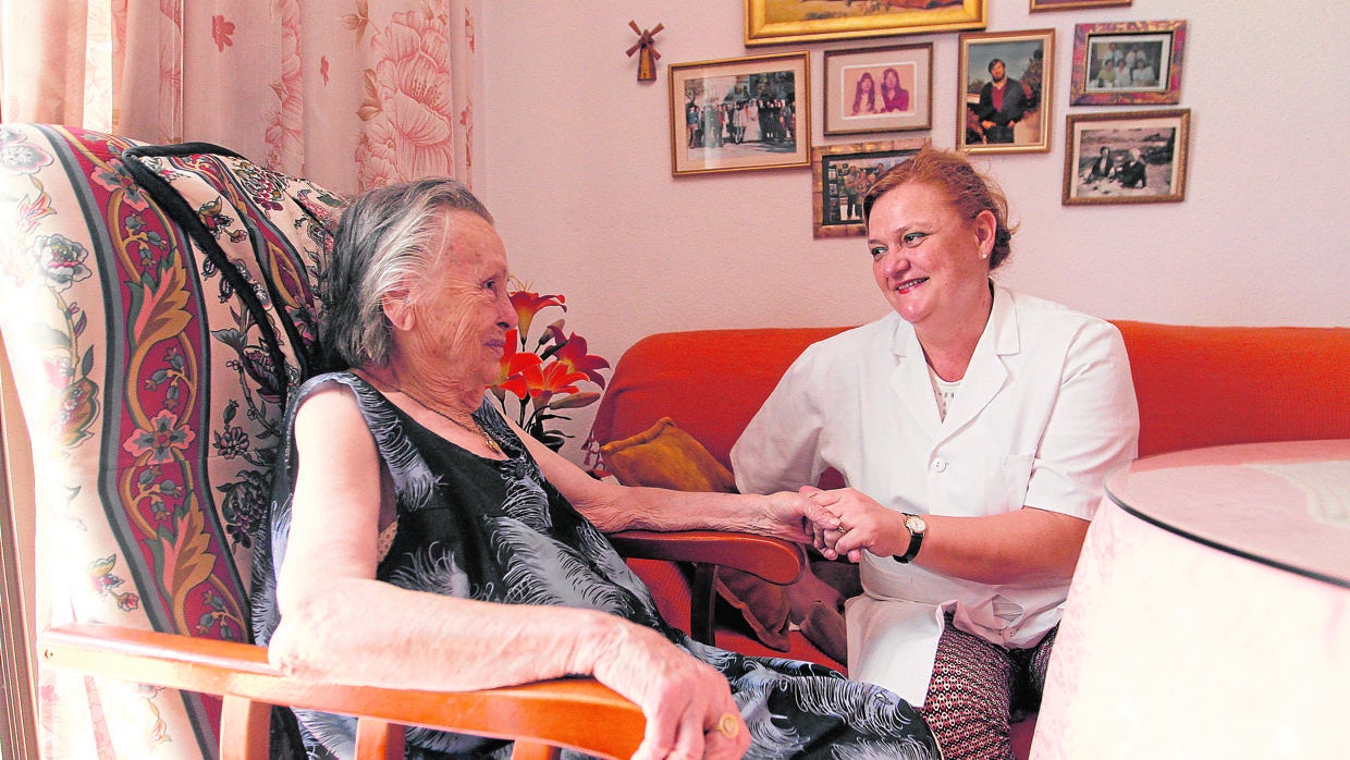 Una usuaria de ayuda a domicilio junto a la mujer que le asiste en casa