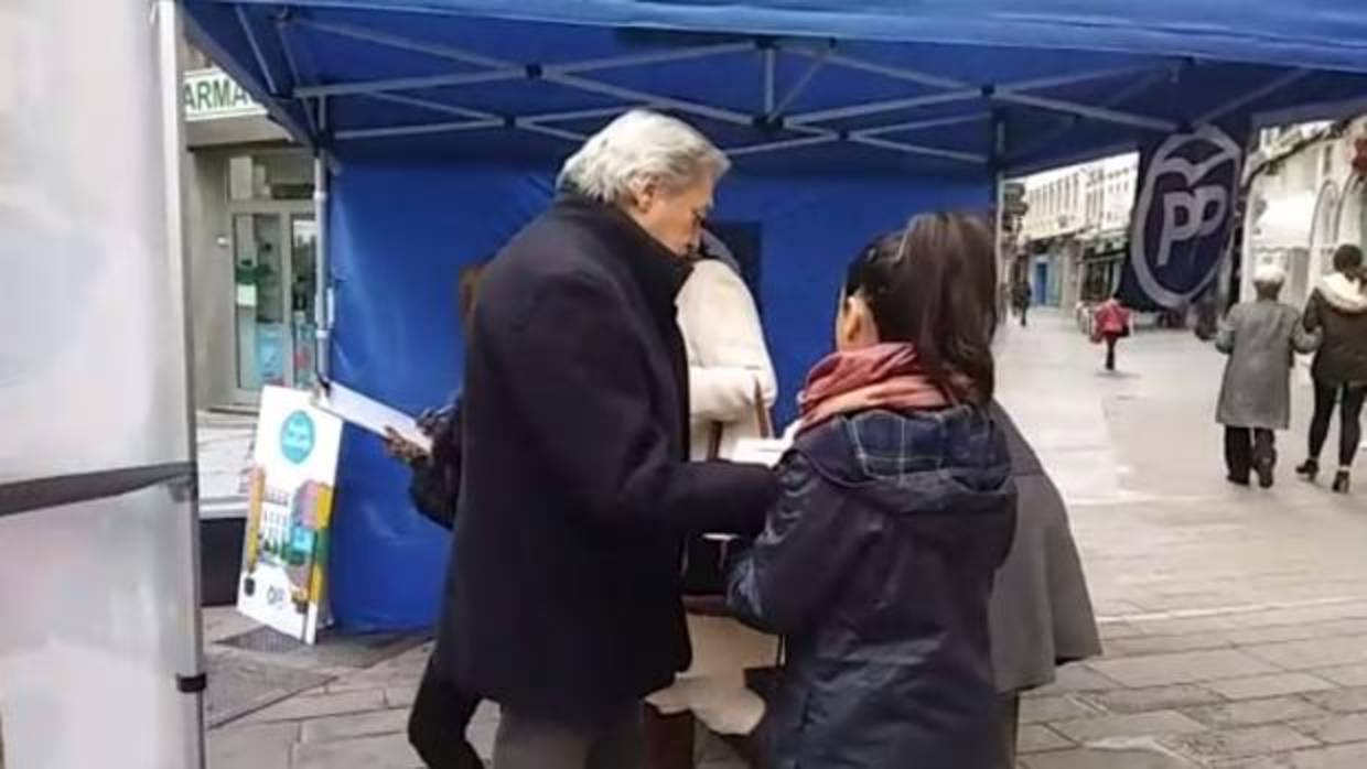 Un ciudadano firma en la caseta instalada por el PP en la calle Cruz Conde
