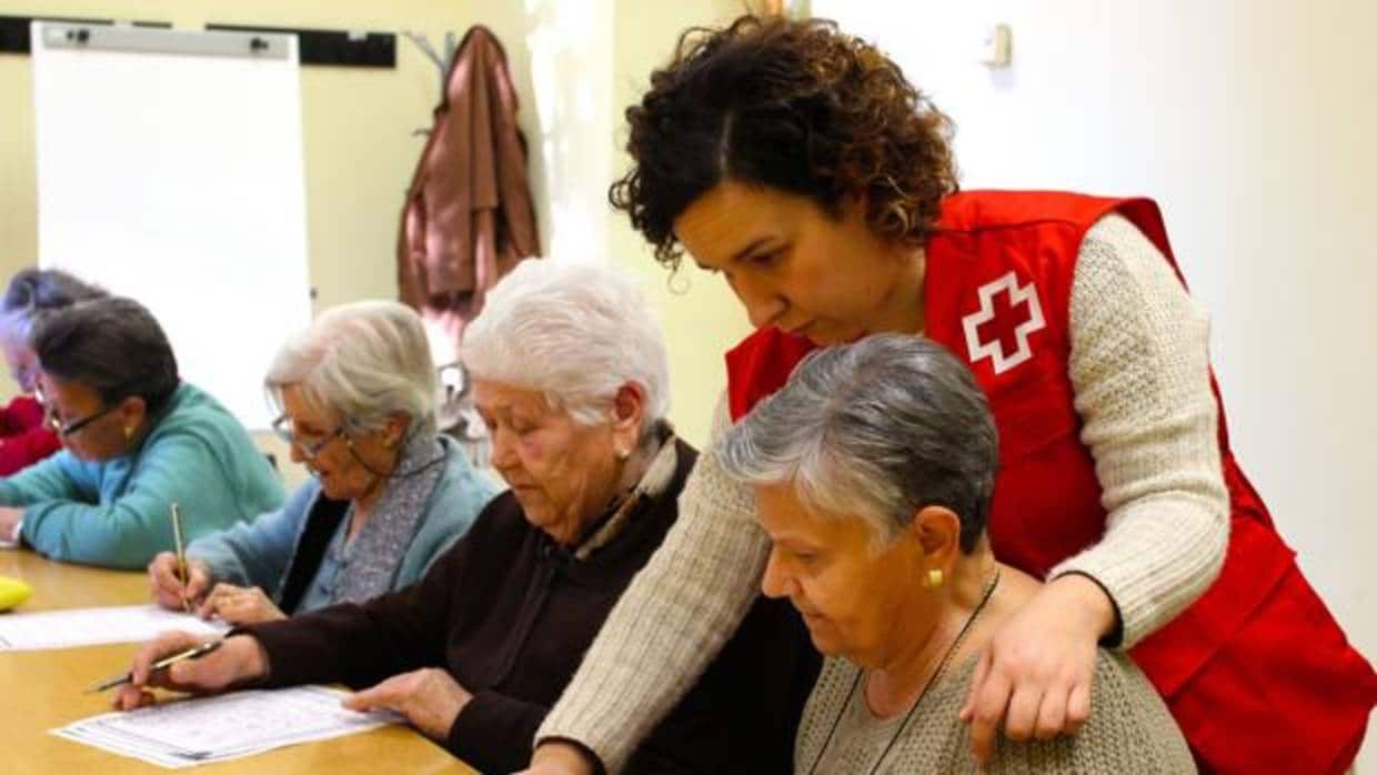 Voluntaria de Cruz Roja atendiendo a mujeres dentro del programa de personas mayores